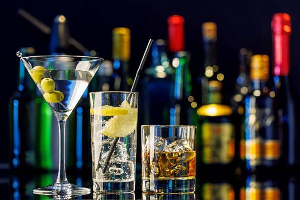 various drinks in front of bottles in the background